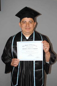 man dark hair holding a high school diploma
